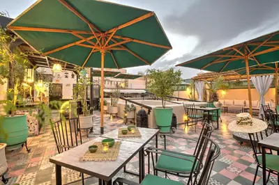 a patio with tables and chairs and umbrellas at Riad Dar Fanny in Marrakech
