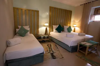 a hotel room with two beds and a table at Riad Dar Fanny in Marrakech