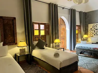 a bedroom with two beds with lamps and a window at Riad Dar Fanny in Marrakech