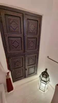 a large wooden wall with a lamp in front of it at The Douiria in Marrakech