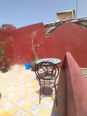 a table and chair sitting on a patio at Riad 9 Derb El Bousnne in Marrakech