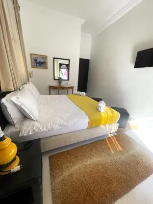 a bedroom with a bed with a yellow blanket at Majorel Perle Hôtel Riad Restaurant Picine & Spa in Marrakech