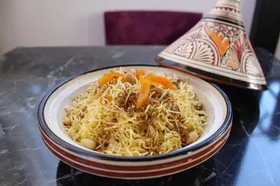 a bowl of noodles with carrots on a table at Majorel Perle Hôtel Riad Restaurant Picine & Spa in Marrakech