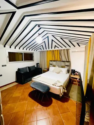 a bedroom with a large bed and a couch at RIAD DOUIRTNA in Marrakech