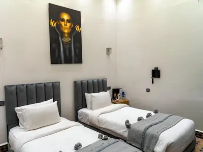 two beds sitting next to each other in a room at RIAD DOUIRTNA in Marrakech