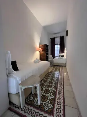 a bedroom with a bed and a table in a room at RIAD ENNAFOURA BOUTIQUE HOTEL in Marrakech