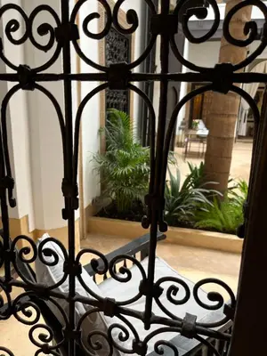 an iron gate with a bench in front of a courtyard at RIAD ENNAFOURA BOUTIQUE HOTEL in Marrakech