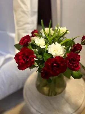 a vase filled with red and white flowers on a table at RIAD ENNAFOURA BOUTIQUE HOTEL in Marrakech