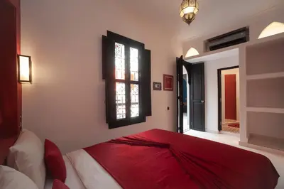 a bedroom with a red bed and a window at Riad Mylaya in Marrakech