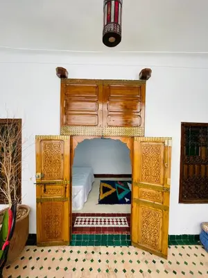 a bedroom with a bed with a wooden bed frame at Archduke private rooms in Marrakech