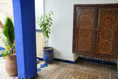 a room with a wooden door and a potted plant at Archduke private rooms in Marrakech