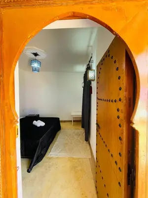 a room with an archway with a black couch and an open door at Archduke private rooms in Marrakech