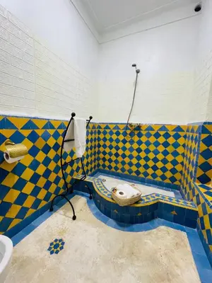 a bathroom with blue and yellow tiled walls and a sink at Archduke private rooms in Marrakech