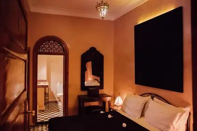 a bedroom with a bed and a mirror and a door at Riad Bensaid in Marrakech