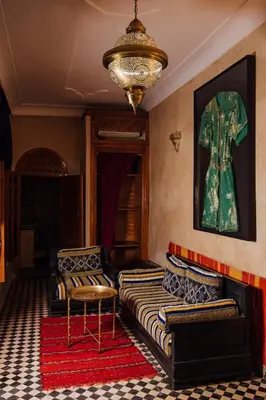 a living room with two beds and a chandelier at Riad Bensaid in Marrakech