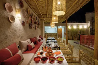 a dining room with a long table with bowls of food at Riad Arabkech in Marrakech