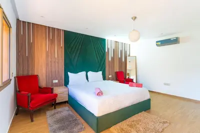 a bedroom with a bed and two red chairs at villa with private pool only family in Marrakech