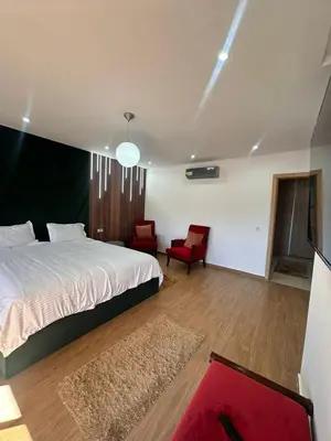 a bedroom with a bed and two red chairs at villa with private pool only family in Marrakech