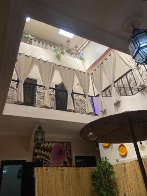 a room with a balcony with white curtains at Riad Paradise privatisé au cœur des souks in Marrakech