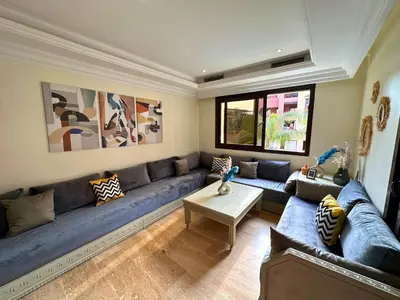 a living room with a blue couch and a table at Appartement Marrakech avec piscine in Marrakech