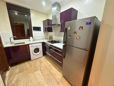 a kitchen with a stainless steel refrigerator and a dishwasher at Appartement Marrakech avec piscine in Marrakech