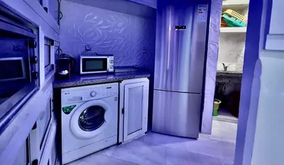 a kitchen with a washing machine and a microwave at Palmeraie 5 Vue Piscine et Jardin in Marrakech