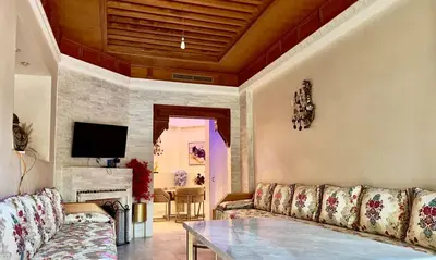 a living room with a couch and a table at Palmeraie 5 Vue Piscine et Jardin in Marrakech