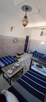 a living room with two beds and a table at Riad chaoui house in Marrakech