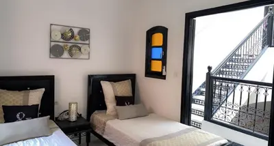 a room with two beds and a staircase with a window at Riad Lyna in Marrakech