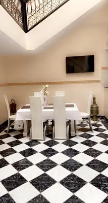 a dining room with a black and white checkered floor at Riad Lyna in Marrakech