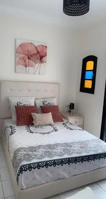 a bedroom with a bed with red pillows at Riad Lyna in Marrakech