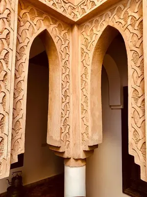 two archways in a wall with a pillar in a room at Riad Laksiba in Marrakech