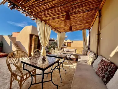 a patio with a couch and tables and chairs at Riad Laksiba in Marrakech