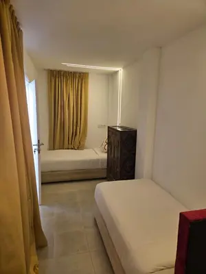 a small bedroom with two beds and a window at Riad Al Hamama in Marrakech