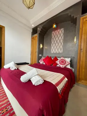 a bedroom with two beds with red and white pillows at Riad Al Hamama in Marrakech