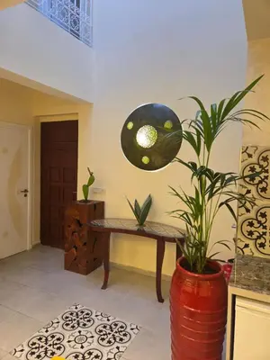 a room with a bench and a potted plant at Riad Al Hamama in Marrakech