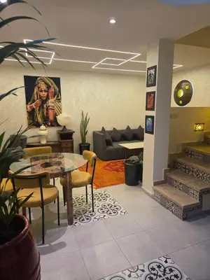 a living room with a table and chairs and a couch at Riad Al Hamama in Marrakech