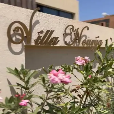 a sign on the side of a building with flowers at Villa Nounja Golf Amelkis Marrakech in Marrakech