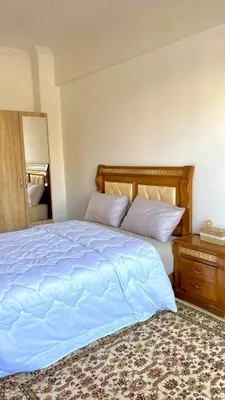 a bedroom with a large bed with a wooden headboard at Luxury Apartment in the center of Gueliz Marrakech in Marrakech
