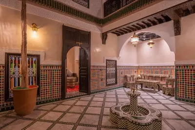a lobby with a table and a bench in a room at Riad Mazaj in Marrakech