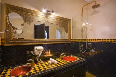 a bathroom with a sink and a mirror at Riad Mazaj in Marrakech