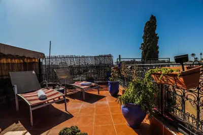 a patio with chairs and plants on a balcony at Riad For S in Marrakech
