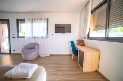 a living room with a tv and a desk and a chair at Villa Arabic House Pool & SPA, Marrakech in Marrakech