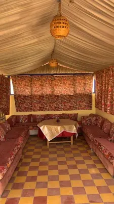 a room with couches and a table in a tent at Riad taddert in Marrakech