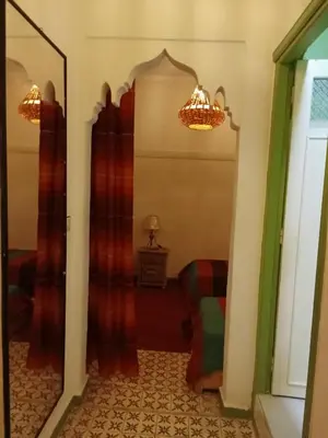 a hallway with red curtains and a mirror at Riad taddert in Marrakech