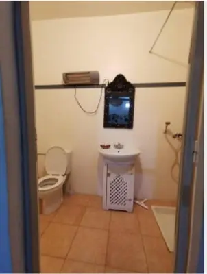 a bathroom with a toilet and a sink and a tv at Riad taddert in Marrakech