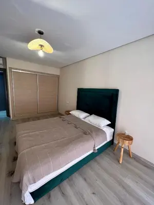 a bedroom with a large bed and a table at Appartement chambre salon centre de Gueliz 22 in Marrakech