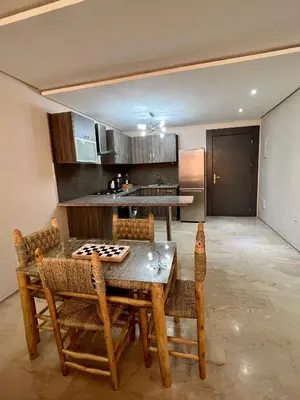 a dining room with a table and chairs and a kitchen at Appartement chambre salon centre de Gueliz 22 in Marrakech