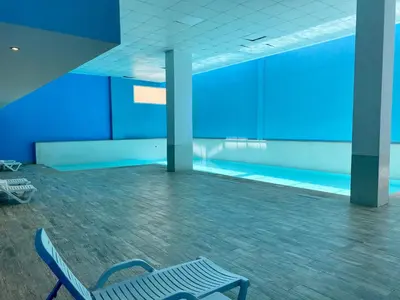 a blue room with a chair and a swimming pool at Appartement chambre salon centre de Gueliz 22 in Marrakech