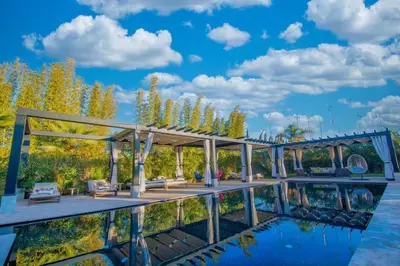 a pavilion on the water with a blue sky at Villa Le Clos de l'Atlas in Marrakech